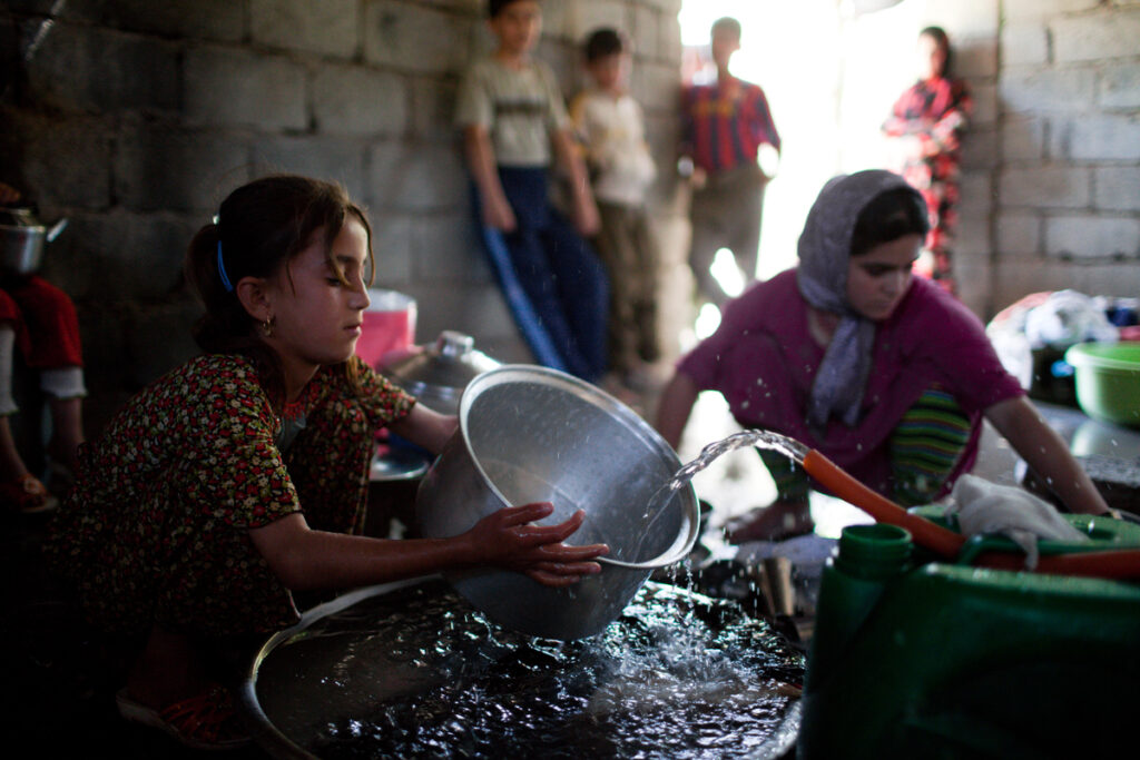 Girl washing dishes in Kunaflusa, northern Iraq